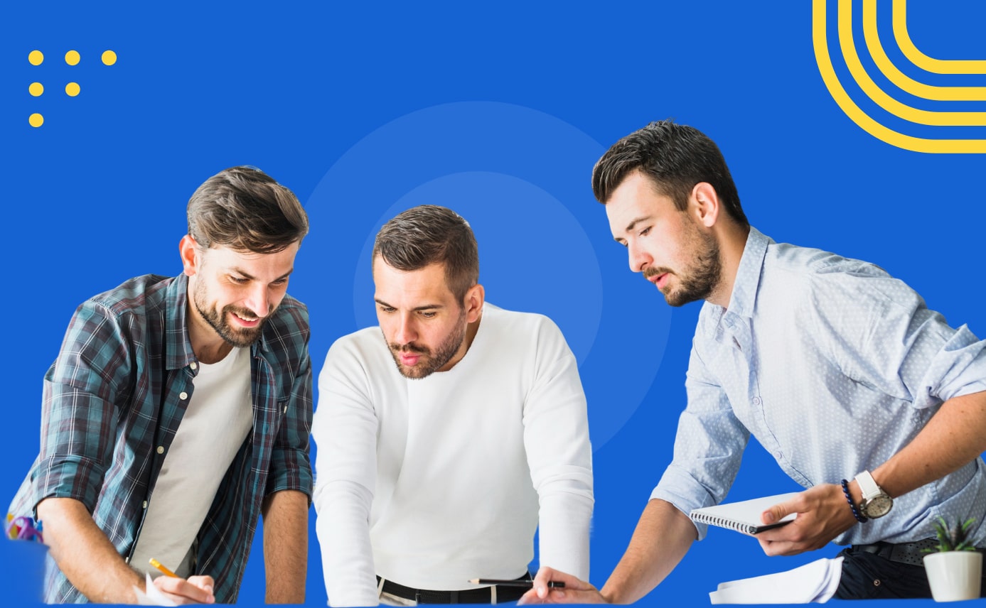 Three men collaborate at a desk, writing and reviewing notes together against a blue background with yellow accents.